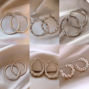 Set of six geometric C-shaped silver earrings with diverse textured and polished designs