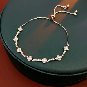 Detailed view of silver clover bracelet with zircon stones and adjustable slider clasp