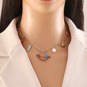 Gold stainless steel necklace with planet, heart, and strawberry charms on a model