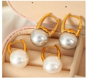 Detailed view of elegant gold pearl drop earrings with lever-back closure in a pink jewelry box