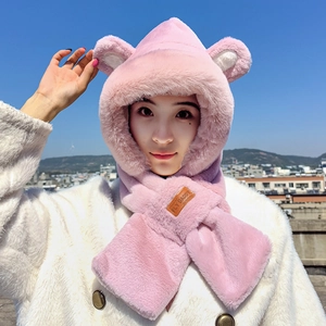 Pink plush hooded scarf with bear ears shown on a model against a city sky backdrop