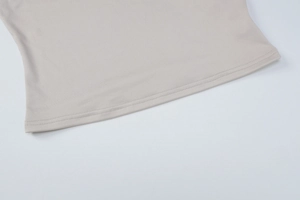Detail shot of the flat double-needle stitching on beige ribbed knit fabric edge