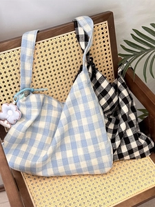 Blue and black plaid canvas tote bags with flower pendant on a vintage chair