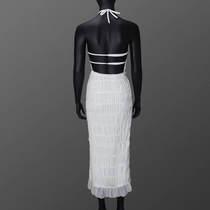 Detailed back view of white halter dress with intricate pleats and tie-back closure