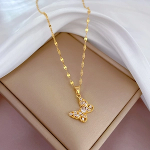 Macro view of golden butterfly pendant with sparkling zircons on elegant leaf-style chain