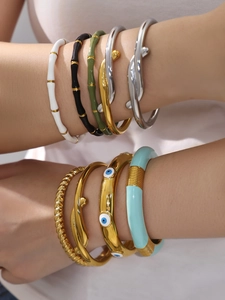 Primo piano di bracciali smaltati a strati con motivi a bambù e ciondoli a occhio greco