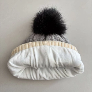 Detail view of thickened white fleece lining and grey cable knit texture on the winter hat