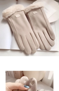 Detail of warm winter gloves in beige suede with touch screen heart embroidery
