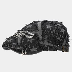 Detail of distressed black denim flat cap featuring star prints and metal star charms