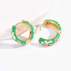 Detailed close-up of green enamel flower earrings with gold plating and buckle closure
