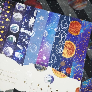 Detailed view of starry universe washi tape with planet and rocket patterns on vintage paper