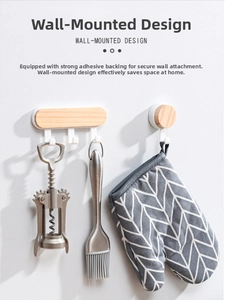 Detail of wooden wall hooks showing adhesive mounting and kitchen tool storage use