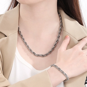 Polished silver stainless steel twist chain necklace and bracelet set on a model