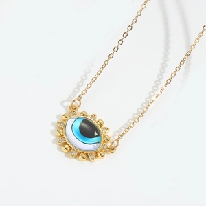 Detailed close-up of golden Devil's Eye pendant with blue oil drip and white zircons