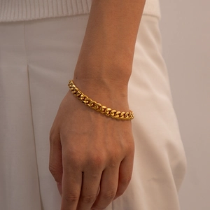 Bracelet élégant à mailles gourmette en acier inoxydable doré porté au poignet féminin
