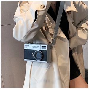 Detail of a vintage camera-shaped crossbody bag featuring black and silver leather textures