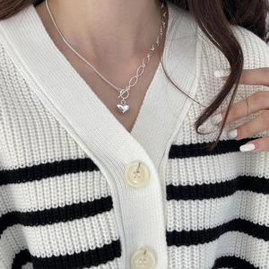 Close-up of heart pendant necklace with asymmetric chain and OT toggle clasp detail