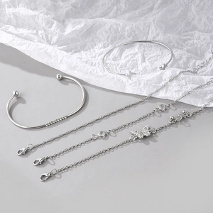 Detail of silver five-piece bracelet set featuring a diamond butterfly and star charms