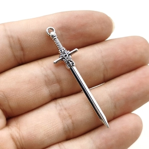 Silver alloy sword pendant for DIY jewelry making shown in hand for size context