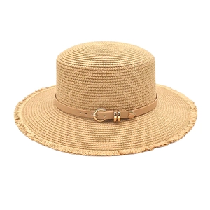 Detail of straw boater hat featuring frayed edges and khaki leather strap with gold buckle