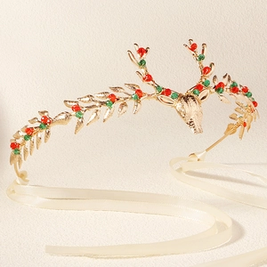 Detailed view of golden reindeer antler headband with red green beads and cream silk ribbons
