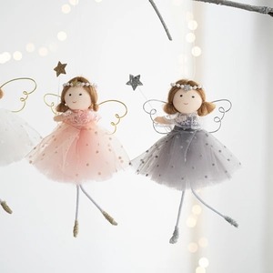 Detailed view of pink mesh angel dolls hanging on branches with warm bokeh lights