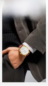 Classic gold watch with white dial and brown leather strap worn by professional male