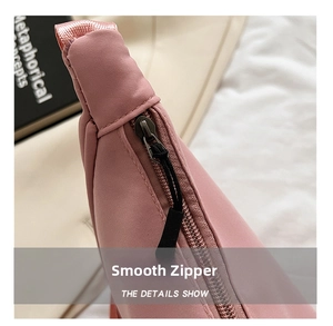 Macro shot of smooth zipper detail with black braided puller on pink nylon bag