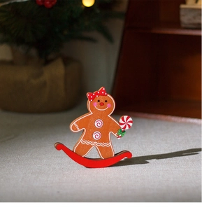 Macro detail of wooden gingerbread man rocking ornament with red polka dot bow and cane