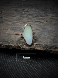 Macro view of June birthstone moonstone set on a vintage bronze adjustable split ring