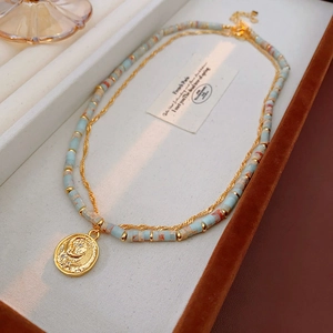 Detail of beaded Shoushan stone necklace with vintage gold moon and star pendant