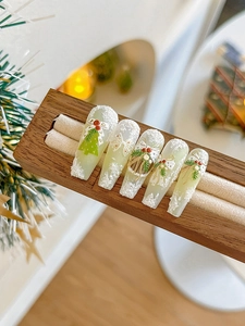 Detail of Christmas nail art stickers with 3D embossed holly and snowflake patterns