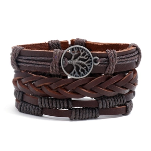 Macro shot of multi-layer brown braided leather bracelet with tree of life metal charm
