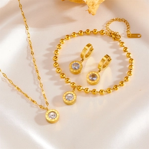 Macro detail of gold stainless steel jewelry set with Roman numeral ring and zircon inlay