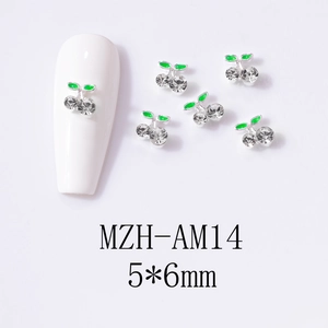Detailed macro view of 3D cherry nail charms with silver base and rhinestones