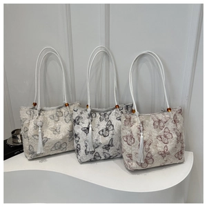 Detailed texture of jacquard fabric tote bags with butterfly prints and silk tassels