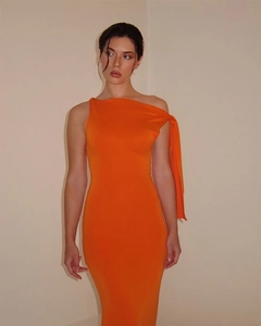 Detailed close-up of the orange one-shoulder slim-fit dress with elastic fabric texture