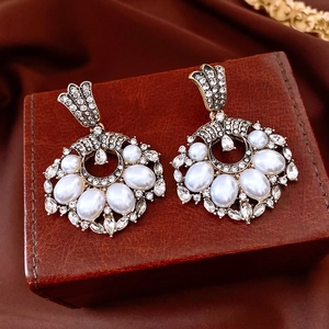 Detailed macro view of vintage style earrings with pearls and rhinestones on leather