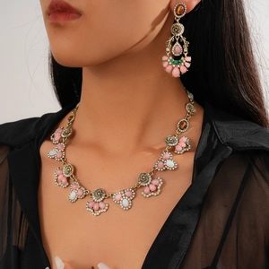 Vintage bronze necklace and earrings set with colorful resin flowers on a female model