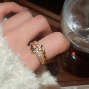 Close-up of a 18k gold-plated criss-cross ring with sparkling zircons on a hand