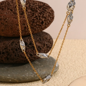Close-up of dual-tone beaded necklace with silver-studded stones on gold-plated chain