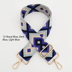 Detail of blue geometric embroidered bag strap with golden lobster clasps and metal hardware