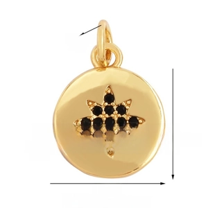 Macro shot of 12mm gold sunburst pendant featuring black gemstone star pattern