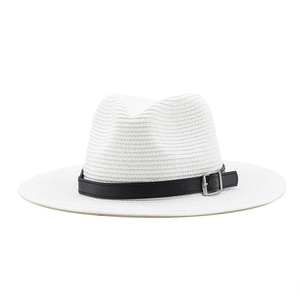 Detail of ivory straw Panama hat featuring a black faux leather band and silver buckle