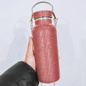 Detail of red rhinestone insulated bottle with metal handle and elegant chain strap