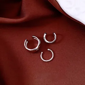 Minimalist 18k white gold plated zircon ear cuff set of three on dark red silk background