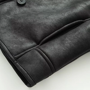 Close-up of black leather jacket featuring premium grain texture and fine stitching detail