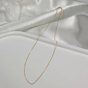 Minimalist S925 sterling silver gold plated box chain necklace on silk background