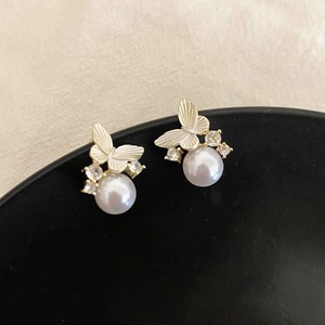 Elegant silver butterfly earrings with white pearls and zircons on a black ceramic plate