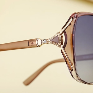 Détail de lunettes de soleil carrées polarisées avec charnière en strass et verre dégradé